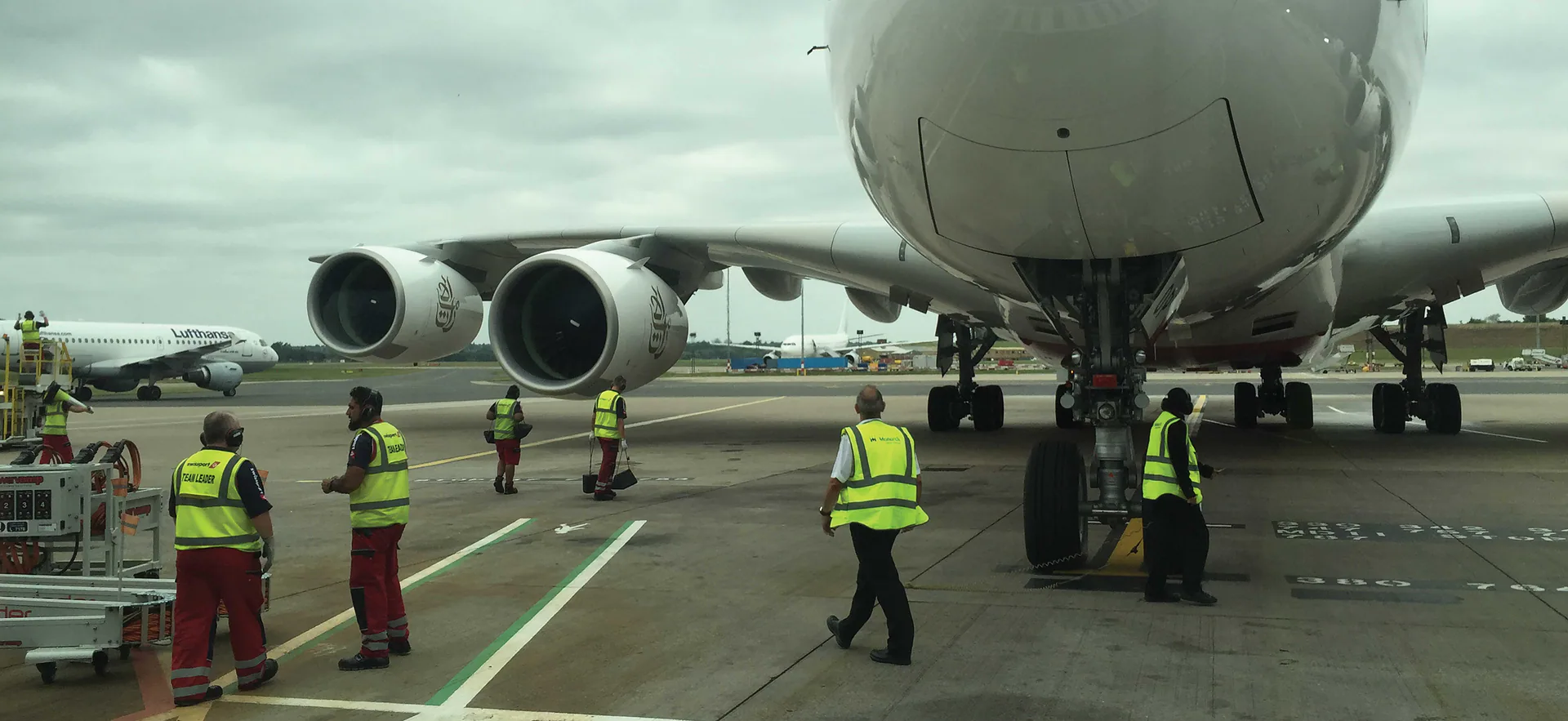 Airport ground crew working around an aircraft on the apron.