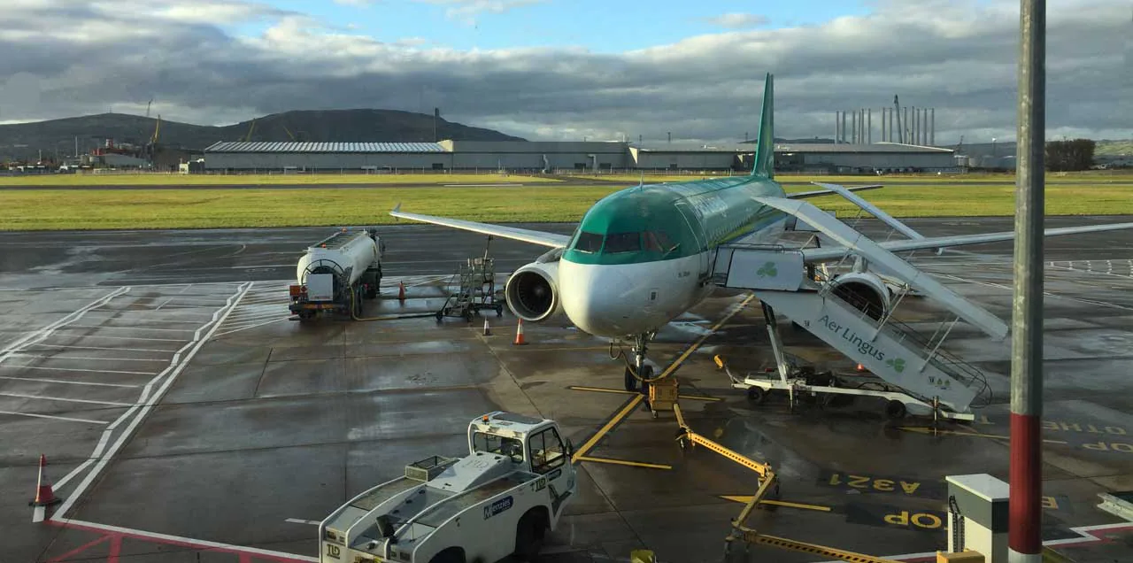 Aer Lingus aircraft on an airport apron with ground support equipment.